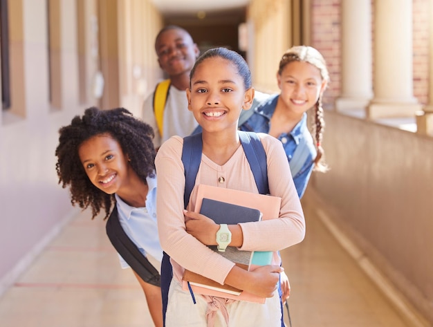 Amis de l'école et portrait d'un groupe d'enfants dans le couloir excités pour l'apprentissage des leçons et la classe Amitié de l'éducation et jeunes étudiants heureux avec des livres de sac à dos et prêts pour l'école primaire