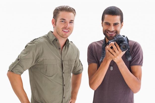 Amis élégants, souriant avec une caméra de maintien