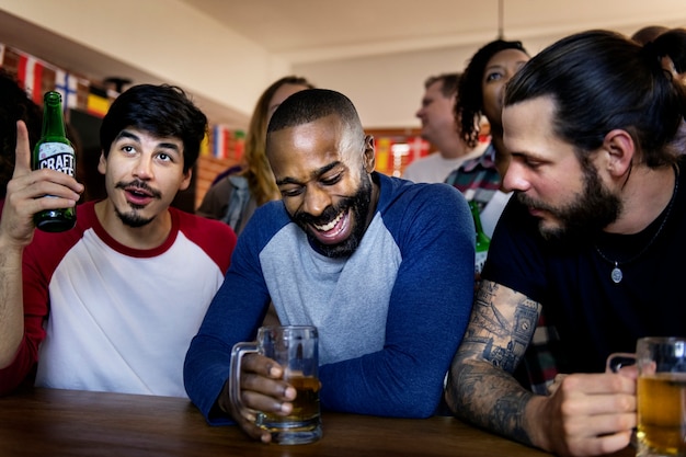 Amis encourageant le sport au bar ensemble