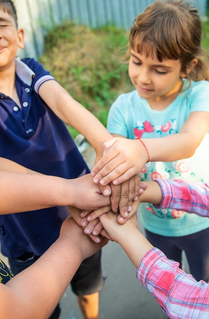 Les Amis Des Enfants Mettent Leurs Mains Ensemble. Mise Au Point Sélective. La Nature.