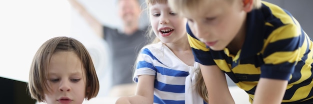 Amis d'enfants occupés à jouer au jeu de cartes sur table à la maison