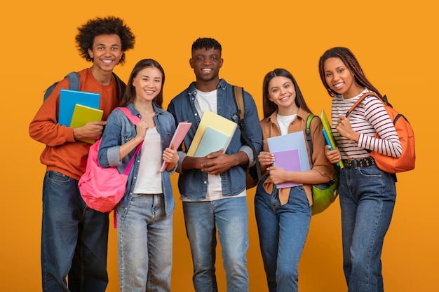 Photo des amis étudiants avec des livres et des sacs à dos souriants