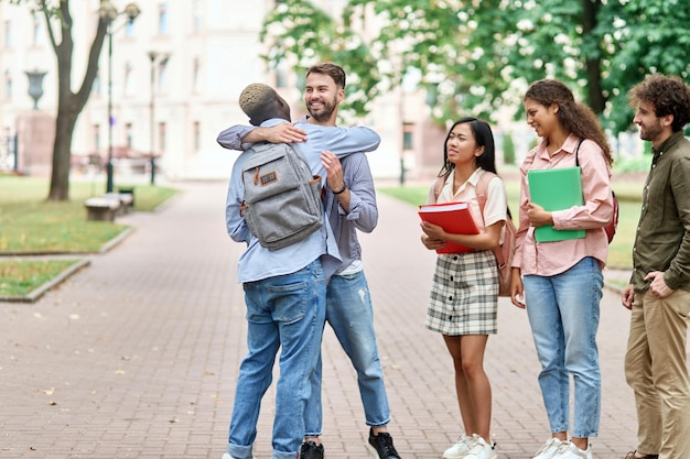 Amis étudiants se serrant les coudes lors de la rencontre