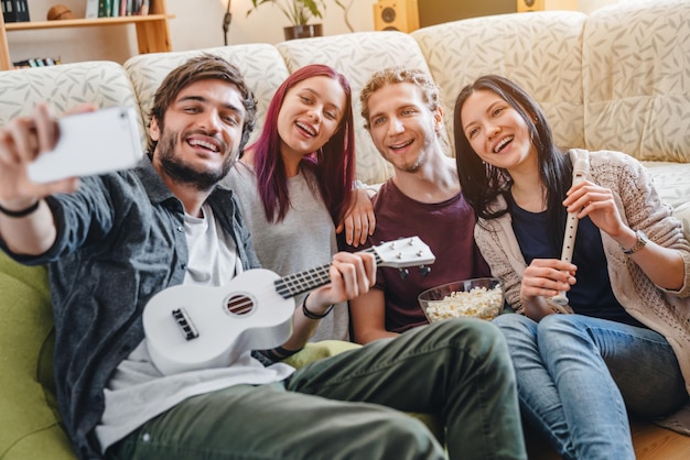 Amis faisant la fête à la maison jouant sur des instruments de musique et s'amusant ensemble