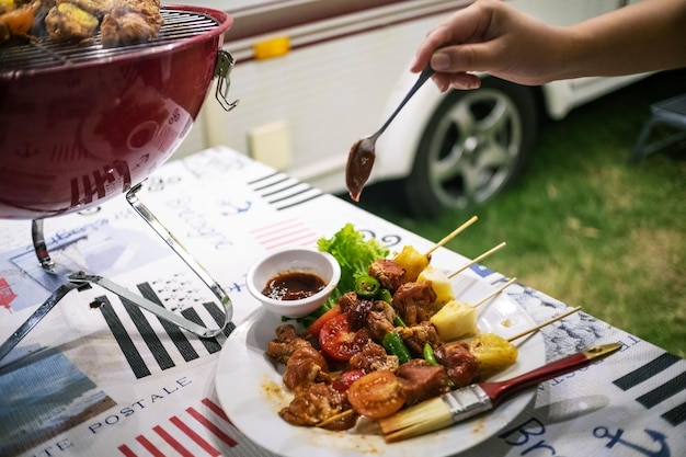 Amis faisant des grillades de barbecue sur un feu chaud dans la natureDîner