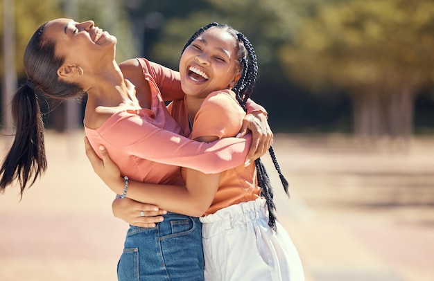 Des amis ou des femmes heureux s'embrassent et rient ensemble dans la nature dans un parc ou une forêt Sourire des sœurs ludiques embrassant les liens profitant d'une journée en plein air et montrant de l'affection et de l'appréciation dans les bois