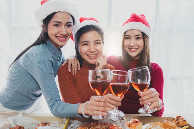 Amis à la fête d'anniversaire tinter des verres avec du champagne et de la pizza profitant de la pizza de vacances de Noël sur la table Événement de fête de vacances