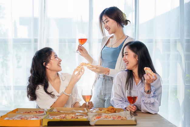 Amis à la fête d'anniversaire tinter des verres avec du champagne et de la pizza profitant de la pizza de vacances de Noël sur la table Événement de fête de vacances