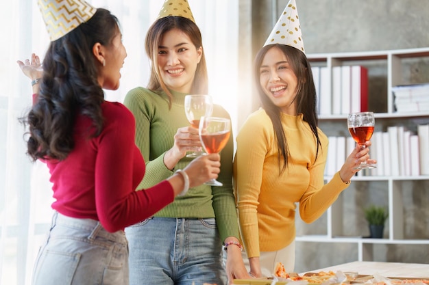 Amis à la fête d'anniversaire tinter des verres avec du champagne et de la pizza profitant de la pizza de vacances de Noël sur la table Événement de fête de vacances