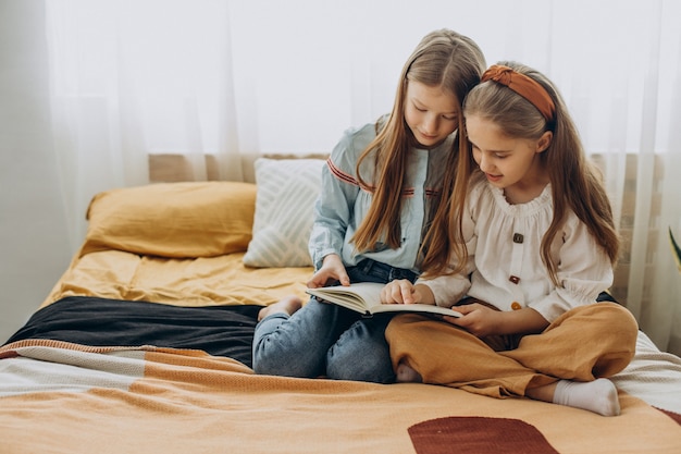 Amis de filles lisant un livre ensemble à la maison