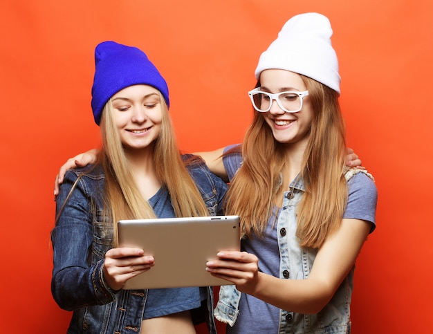 Amis de filles prenant selfie avec tablette numérique