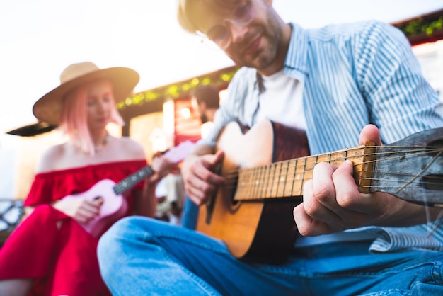 Les amis font un pique-nique et jouent avec de la guitare