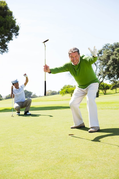 Amis de golf encourageant le putting green