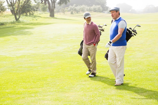 Amis golfeurs marchant et bavardant