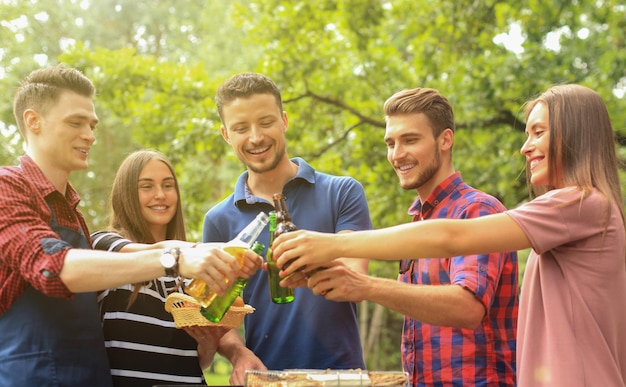 Amis grillant de la bière au barbecue dans la nature