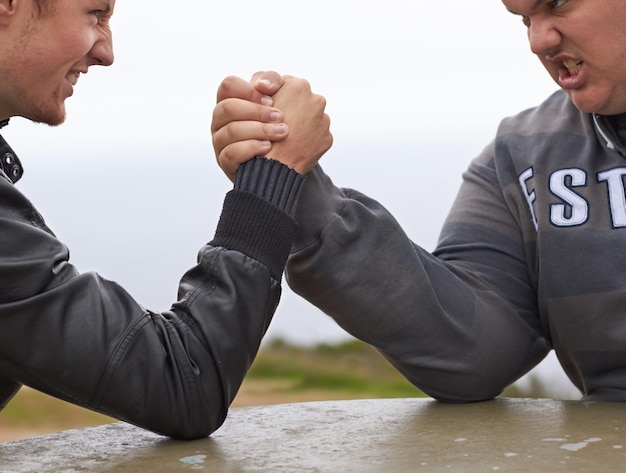 Photo amis en gros plan et compétition avec des hommes et bras de fer dans la nature pour défier le pouvoir et le respect équipe forte et conflit avec les mains des gens et se tenir la main pour un match musculaire et rival