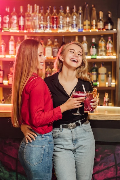 Des amis heureux applaudissent et boivent des cocktails à la fête sur la plage en plein air Les jeunes de la génération Y s'amusent le week-end la nuit d'été Concept de mode de vie et de vie nocturne des jeunes Accent principal sur les gars de gauche