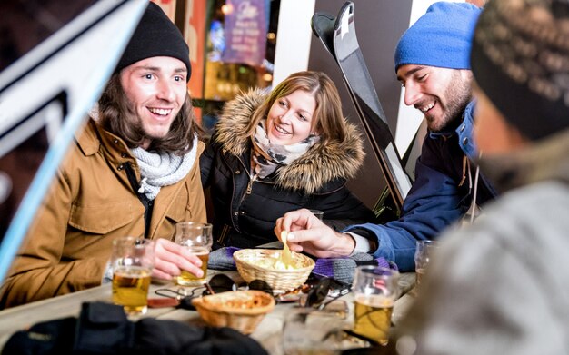 Amis heureux buvant de la bière et mangeant des frites