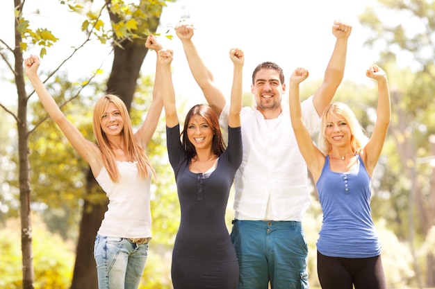 Amis heureux dans la nature avec les bras levés