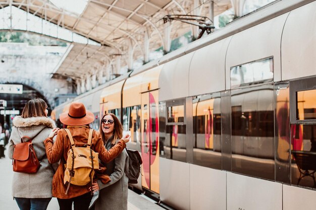 Photo des amis heureux debout sur la gare