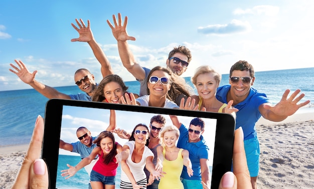 Amis heureux faisant le selfie sur la plage le jour d'été