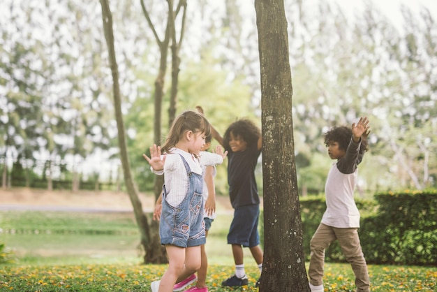 Photo des amis heureux jouant près des arbres dans le parc.