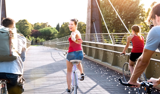 Des amis heureux s'amusant à faire du vélo au parc de la ville