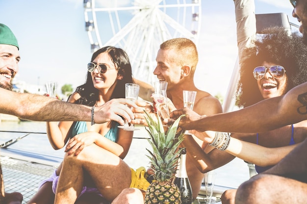 Photo des amis heureux en train de boire des verres par une journée ensoleillée.