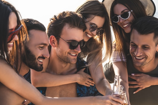 Les amis heureux trinquent en plein air