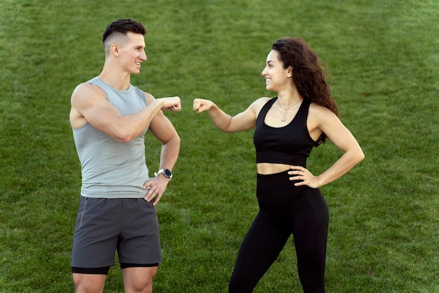 Amis homme et femme se reposant après l'exercice et se cognant les poings après un entraînement réussi