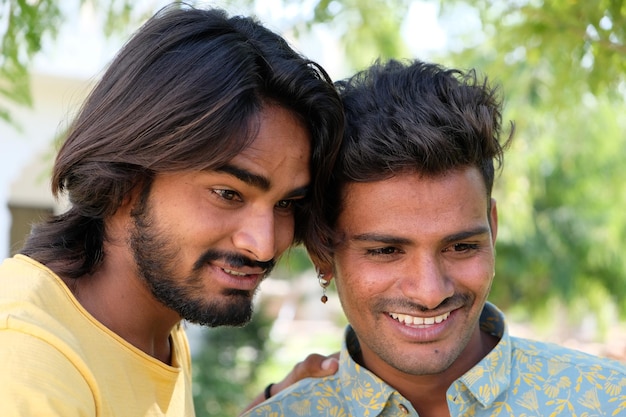 Amis indiens positifs regardant quelque chose et souriant dans un parc