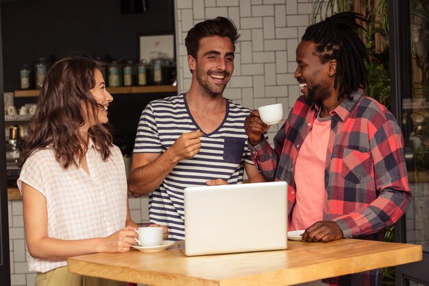 Amis en interaction et ordinateur portable sur la table