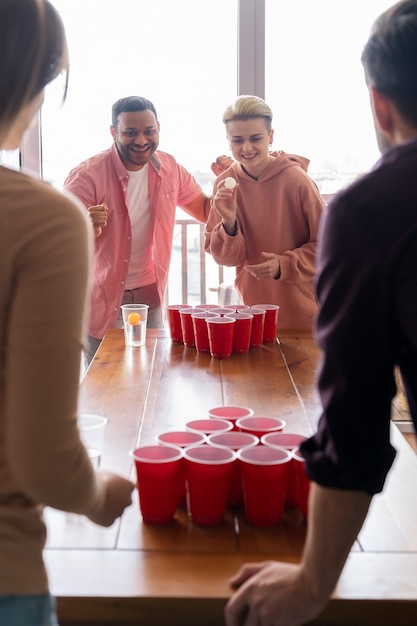 Des amis jouant au beer pong ensemble à une fête.