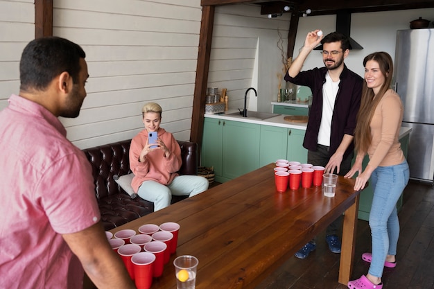 Photo amis jouant au beer pong ensemble lors d'une fête