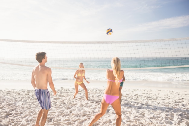 Amis jouant au volleyball de plage