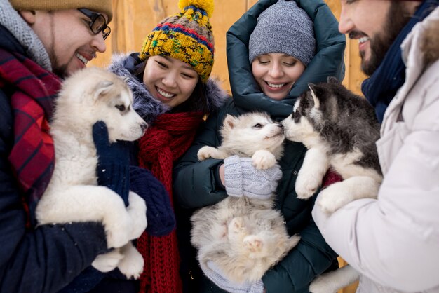 Amis jouant avec des chiots mignons