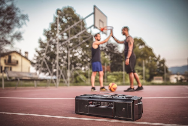 amis jouent au basket-ball sur un terrain extérieur