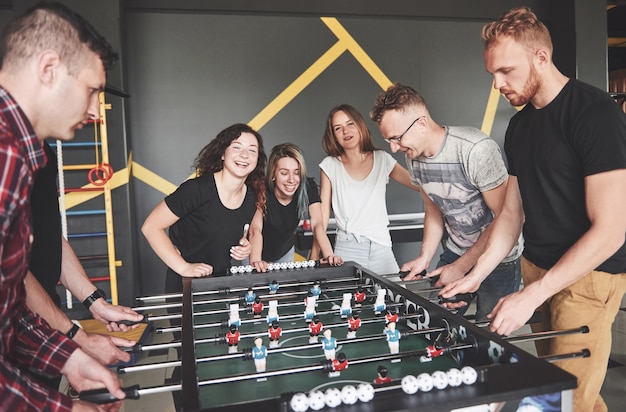 Les amis jouent ensemble à des jeux de société, au baby-foot, s'amusent pendant leur temps libre.