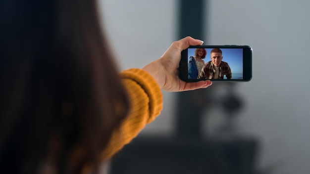 Des amis joyeux appelant en vidéoconférence sur un voyage en gros plan une fille agitant l'écran de son smartphone