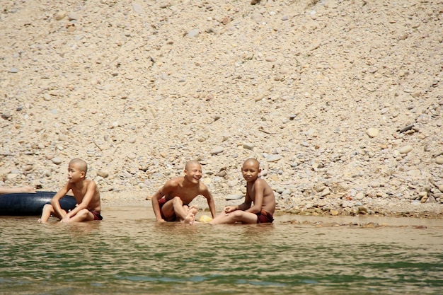 Photo des amis joyeux jouant dans le lac.