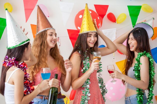 Photo des amis joyeux tenant des boissons à une fête