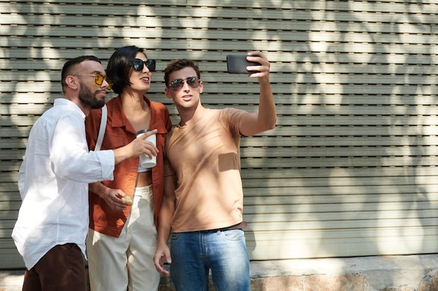 Amis à lunettes de soleil prenant Selfie