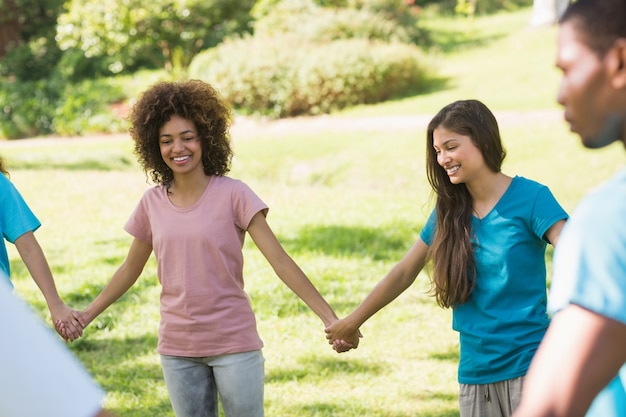 Amis, main dans la main en cercle au parc