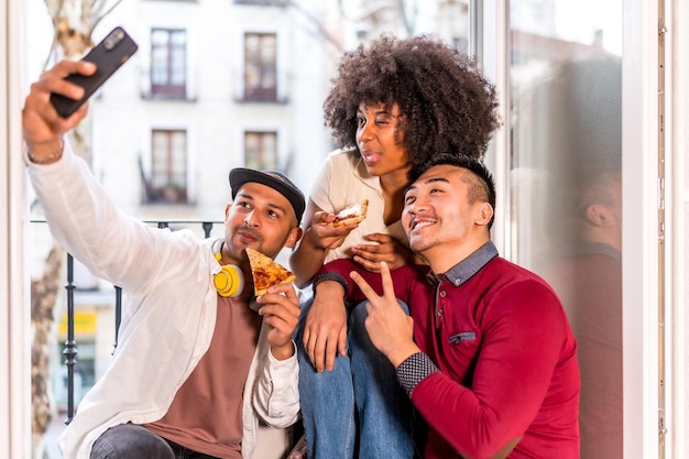 Amis mangeant de la pizza sur la terrasse à la maison déjeuner ou dîner style de vie concept gastronomique s'amusant à prendre une photo