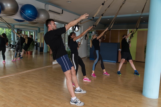 Amis masculins et féminins travaillant avec Trx in Gym