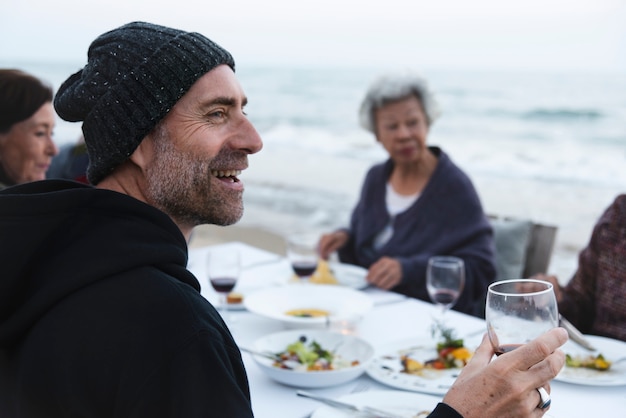 Amis matures buvant du vin à la plage