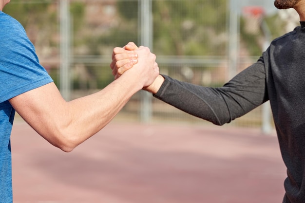 Des amis méconnaissables qui se tapent sur le concept de terrain de sport et d'amitié