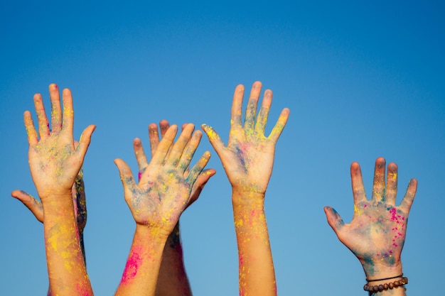 Amis métisses multiculturels multinationaux dans la poussière de holi sur la plage de Goa