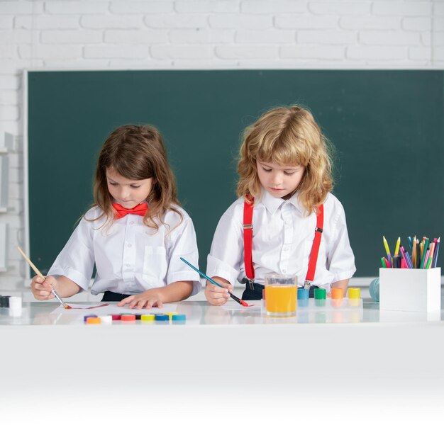 Amis mignons enfants dessinant et peignant à l'école sympathique garçon une fille élèves drôles dessiner l'amitié je