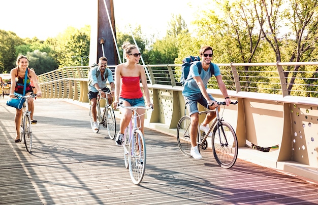 Amis milenial heureux s'amusant à faire du vélo au pont du parc de la ville